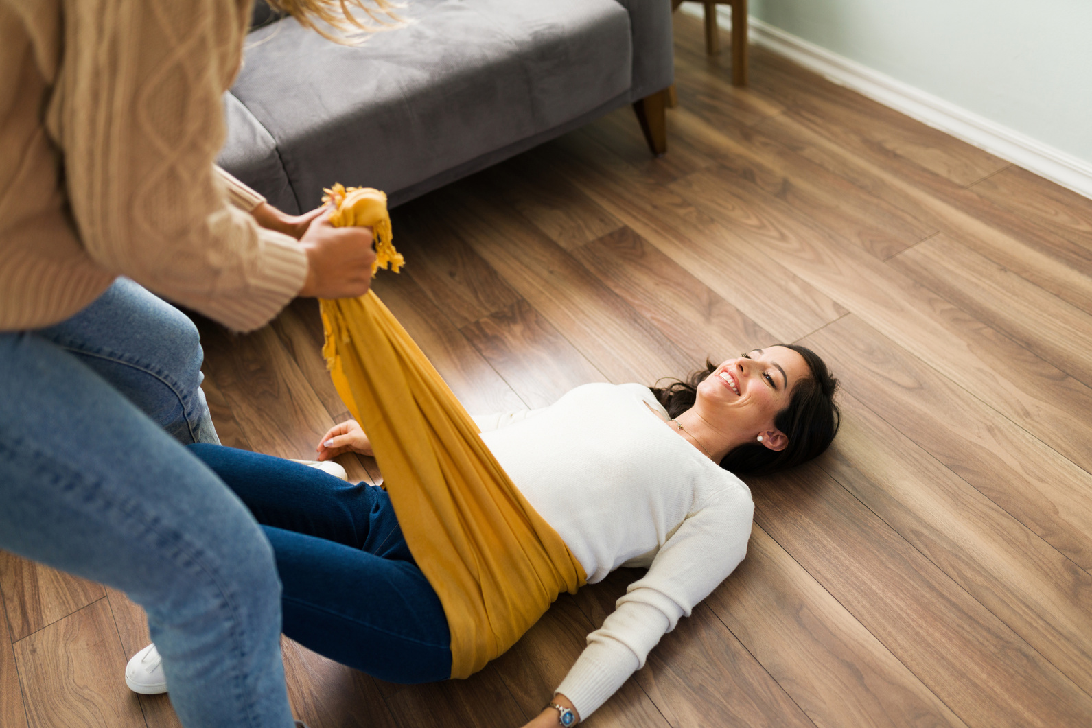 Woman feeling happy while a doula wraps a rebozo around her belly